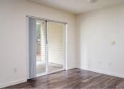 Thumbnail 17 of 50 - an empty living room with a sliding glass door to a patio at Quail Run Apartments, Vancouver, WA