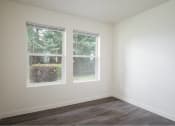 Thumbnail 18 of 50 - an empty room with two windows and a wood floor at Quail Run Apartments, WA