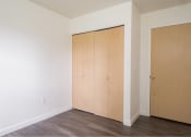 Thumbnail 19 of 50 - an empty room with white walls and wood floors and two closets at Quail Run Apartments, Vancouver, 98684
