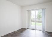 Thumbnail 20 of 50 - an empty living room with a sliding glass door to a yard at Quail Run Apartments, Vancouver, WA