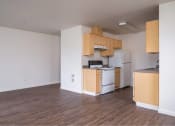 Thumbnail 22 of 50 - an empty kitchen with wooden cabinets and a white refrigerator at Quail Run Apartments, Washington 98684