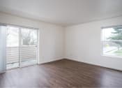 Thumbnail 23 of 50 - an empty living room with wood floors and a sliding glass door at Quail Run Apartments, Vancouver, Washington