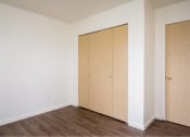 Thumbnail 24 of 50 - an empty room with white walls and wood floors and a closet at Quail Run Apartments, Vancouver, WA 98684