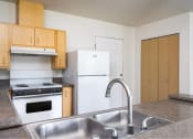 Thumbnail 27 of 50 - a kitchen with a sink and a stove and a refrigerator at Quail Run Apartments, WA