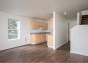 Thumbnail 31 of 50 - an empty living room and kitchen with wood floors at Quail Run Apartments, WA