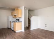 Thumbnail 32 of 50 - an empty living room with a kitchen and a staircase at Quail Run Apartments, Vancouver