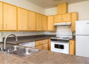 Thumbnail 36 of 50 - a kitchen with wooden cabinets and a sink at Quail Run Apartments, Vancouver
