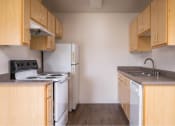 Thumbnail 43 of 50 - an empty kitchen with a stove refrigerator and sink at Quail Run Apartments, Vancouver, WA 98684