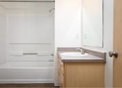 Thumbnail 46 of 50 - a bathroom with a sink and a shower and a mirror at Quail Run Apartments, WA