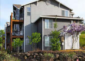 Thumbnail 5 of 46 - a gray house with a deck on the side of it at Troutdale Terrace, Troutdale, OR