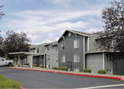 Thumbnail 8 of 46 - an apartment building with gray siding and a red curb at Troutdale Terrace, Troutdale, OR