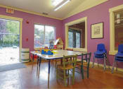 Thumbnail 22 of 46 - a play room with activity table  with a long table and chairs at Troutdale Terrace, Troutdale, OR 97060