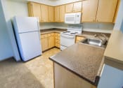 Thumbnail 39 of 46 - a kitchen with a white refrigerator and a sink at Troutdale Terrace, Troutdale, OR 97060