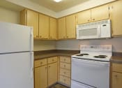 Thumbnail 41 of 46 - a kitchen with a stove microwave and refrigerator at Troutdale Terrace, Troutdale, Oregon