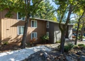 Thumbnail 5 of 49 - side view of a brown house with trees and a sidewalk at Whisperwood, Washington 98168