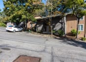 Thumbnail 19 of 49 - a car parked in front of a brown apartment at Whisperwood, Seattle, 98168