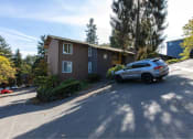 Thumbnail 20 of 49 - a brown house with a car parked in front of it at Whisperwood, Seattle, Washington