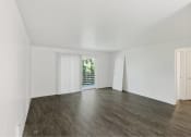 Thumbnail 32 of 49 - an empty living room with white walls and wood floors at Whisperwood, Seattle, Washington