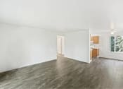 Thumbnail 35 of 49 - an empty living room with white walls and wood floors at Whisperwood, Seattle, 98168