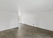 Thumbnail 36 of 49 - an empty living room with white walls and wood floors at Whisperwood, Seattle, WA 98168