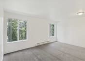 Thumbnail 38 of 49 - an empty living room with two windows and carpet at Whisperwood, Seattle, WA 98168