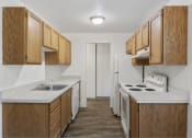 Thumbnail 43 of 49 - a small kitchen with white counter tops and wooden cabinets at Whisperwood, Seattle