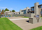 Thumbnail 59 of 63 - A concrete structure sits in the middle of a grassy area in front of apartment buildings at The Henley Apartments, Suisun City, CA