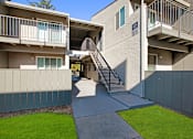 Thumbnail 58 of 63 - A concrete building with a staircase leading to the entrance at The Henley Apartments, Suisun City, 94585