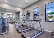 Thumbnail 10 of 63 - A gym with treadmills, weights, and exercise equipment at The Henley Apartments, Suisun City, CA