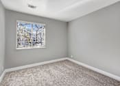 Thumbnail 43 of 63 - A room with a window and carpeted floor at The Henley Apartments, Suisun City, California