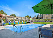 Thumbnail 7 of 63 - A green umbrella is next to a pool at The Henley Apartments, Suisun City, CA, 94585