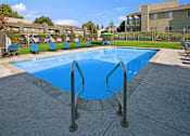 Thumbnail 6 of 63 - A large blue swimming pool with a metal ladder at The Henley Apartments, Suisun City, CA, 94585