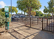 Thumbnail 16 of 63 - A gated entrance to a park with a sign for a walking trail at The Henley Apartments, Suisun City