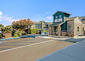 Thumbnail 2 of 63 - A sunny day at the entrance of a building with a sign at The Henley Apartments, Suisun City, California