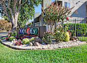 Thumbnail 63 of 63 - A sign for Tenley Homes is surrounded by flowers and plants at The Henley Apartments, California, 94585