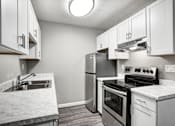 Thumbnail 17 of 63 - A kitchen with a stove, oven, and sink at The Henley Apartments, Suisun City, California