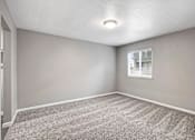 Thumbnail 39 of 63 - A room with a carpeted floor and a window with blinds at The Henley Apartments, California, 94585