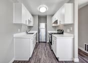 Thumbnail 25 of 63 - A kitchen with white cabinets and a stainless steel refrigerator at The Henley Apartments, Suisun City, CA