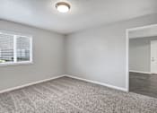 Thumbnail 26 of 63 - A room with a carpeted floor, a window with blinds, and a door at The Henley Apartments, Suisun City, 94585