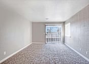 Thumbnail 27 of 63 - A room with a carpeted floor and a sliding glass door at The Henley Apartments, Suisun City, California