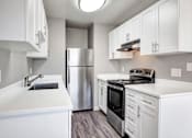 Thumbnail 22 of 63 - A modern kitchen with white cabinets and stainless steel appliances at The Henley Apartments, Suisun City, CA, 94585