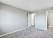 Thumbnail 31 of 63 - A room with a carpeted floor and a white door at The Henley Apartments, Suisun City, CA