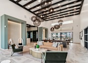 Thumbnail 1 of 32 - A modern living room with a green chair and a brown couch at Ironwood Ranch Apartments,Maricopa,Arizona