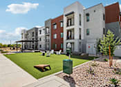 Thumbnail 29 of 32 - A modern apartment complex with a green lawn and a bench at Ironwood Ranch Apartments,Maricopa,Arizona