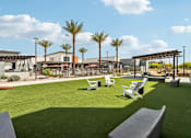 Thumbnail 12 of 32 - A sunny day at the park with palm trees and a playground at Ironwood Ranch Apartments,Maricopa,85138