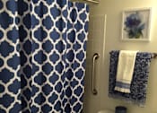 Thumbnail 5 of 10 - A blue and white shower curtain in a bathroom at Tabco Towers Apartments, Towson, Maryland