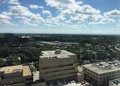 Thumbnail 10 of 10 - A view of a city from a high vantage point with buildings and cars visible at Tabco Towers Apartments, Towson, MD, 21286