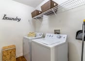 Thumbnail 24 of 24 - A small laundry room with a washer and dryer at The Villages on Millenia Apartments, Orlando, FL, 32839