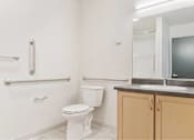 Thumbnail 29 of 29 - Bathroom with white toilet at Bridge Meadows Redmond Apartments, Oregon