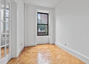 Thumbnail 11 of 17 - A room with a window and a wooden floor.